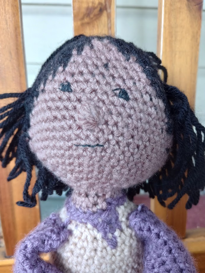 A close-up of the doll's face, showing his tiny smile