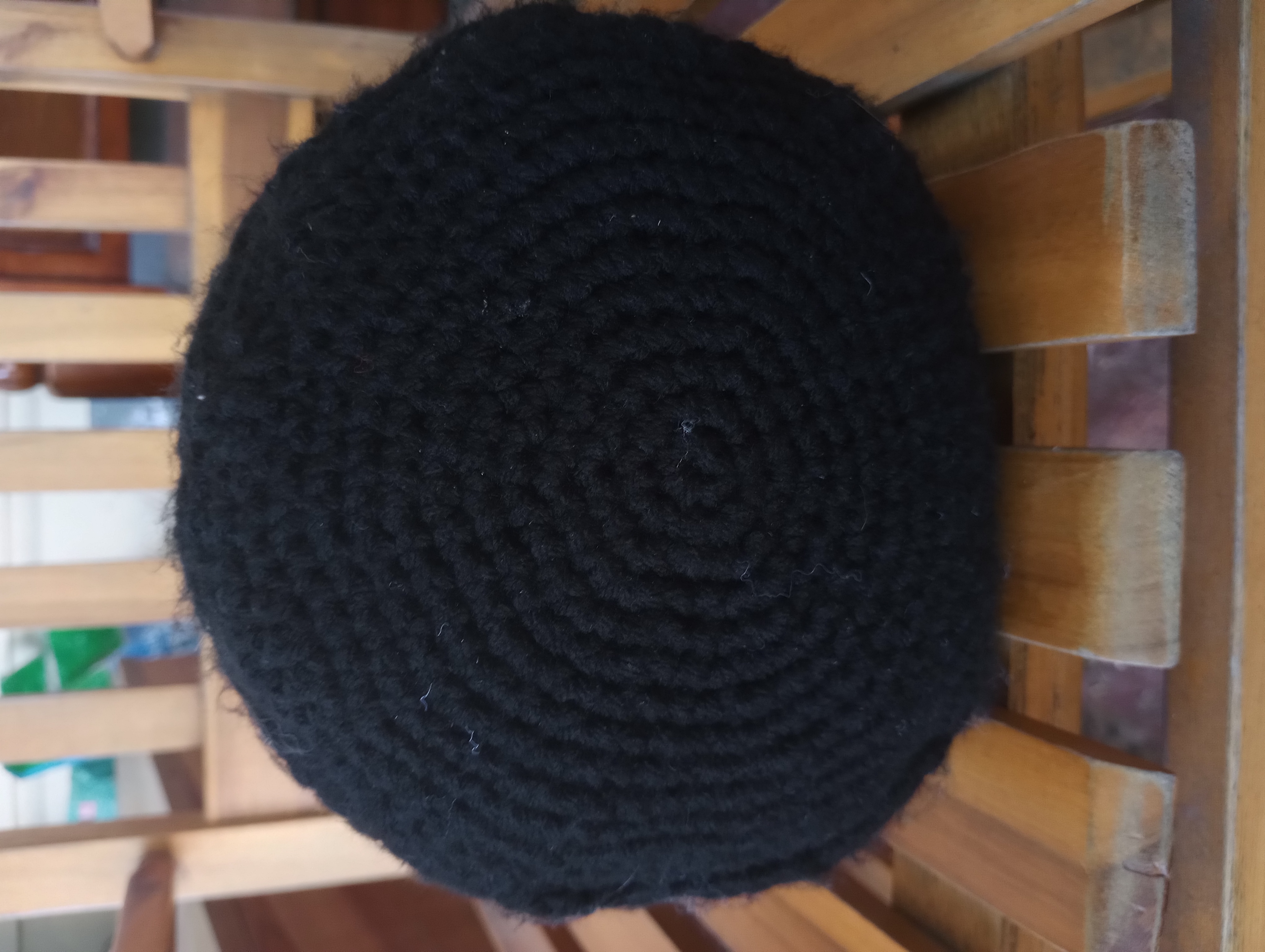 The base of the doll, a crocheted black circle with irregular edges.