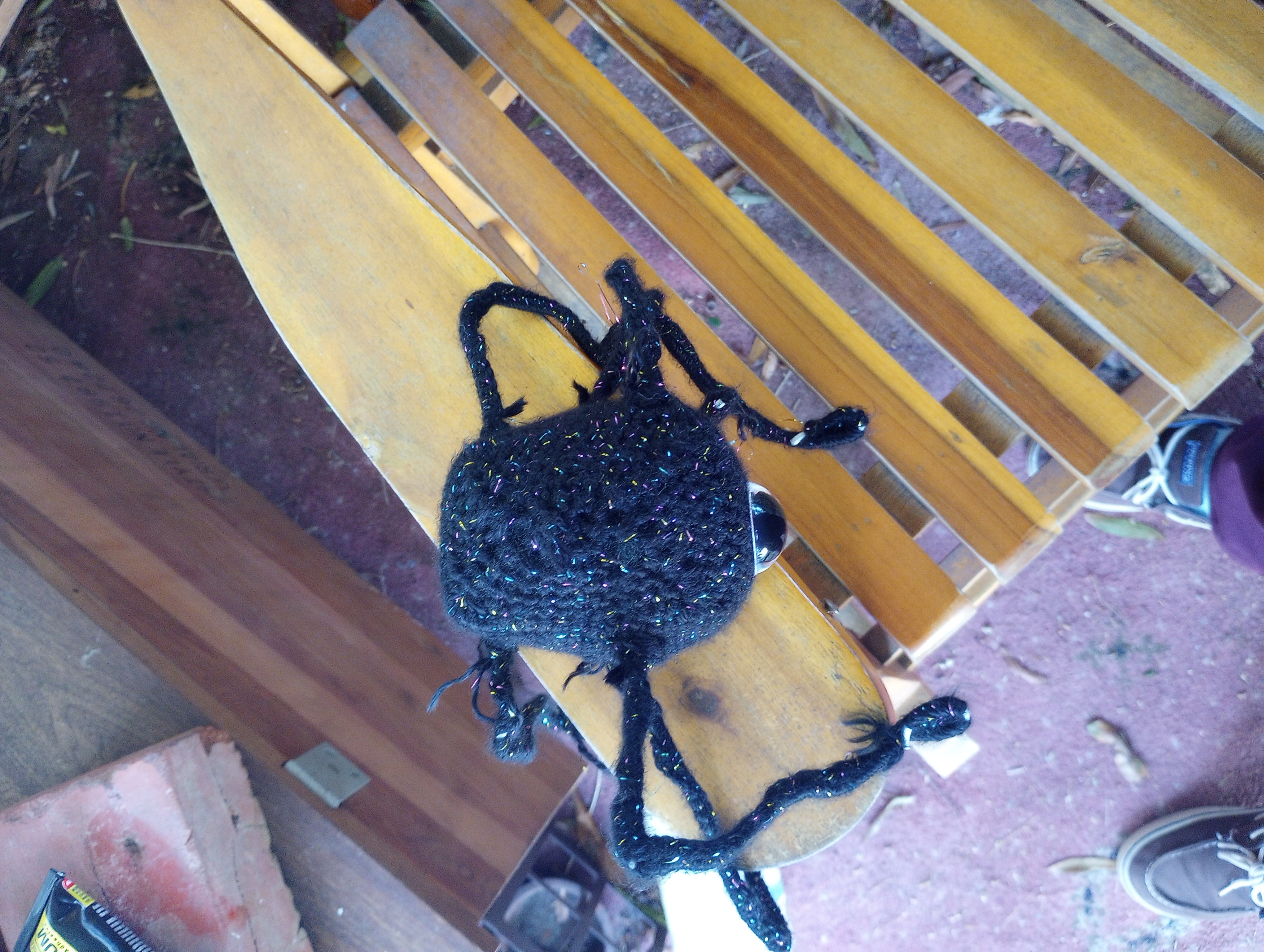 The crocheted robot seen from the top, displaying that it is roughly rectangular