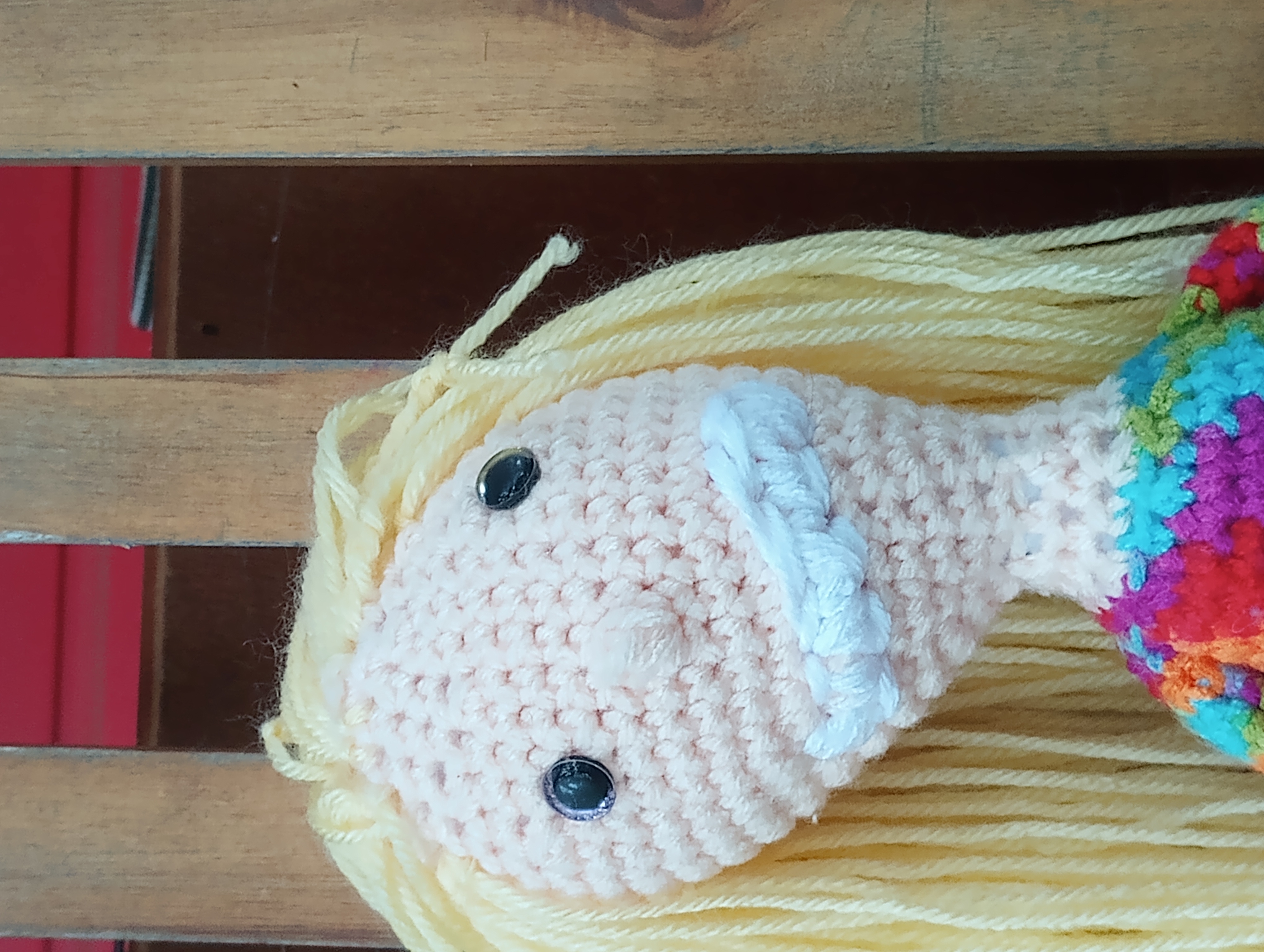 A close-up of the doll's head and face, showing off the mismatched eyes, a few random tangled/knotted strands in the hair, and the preternaturally large smile.