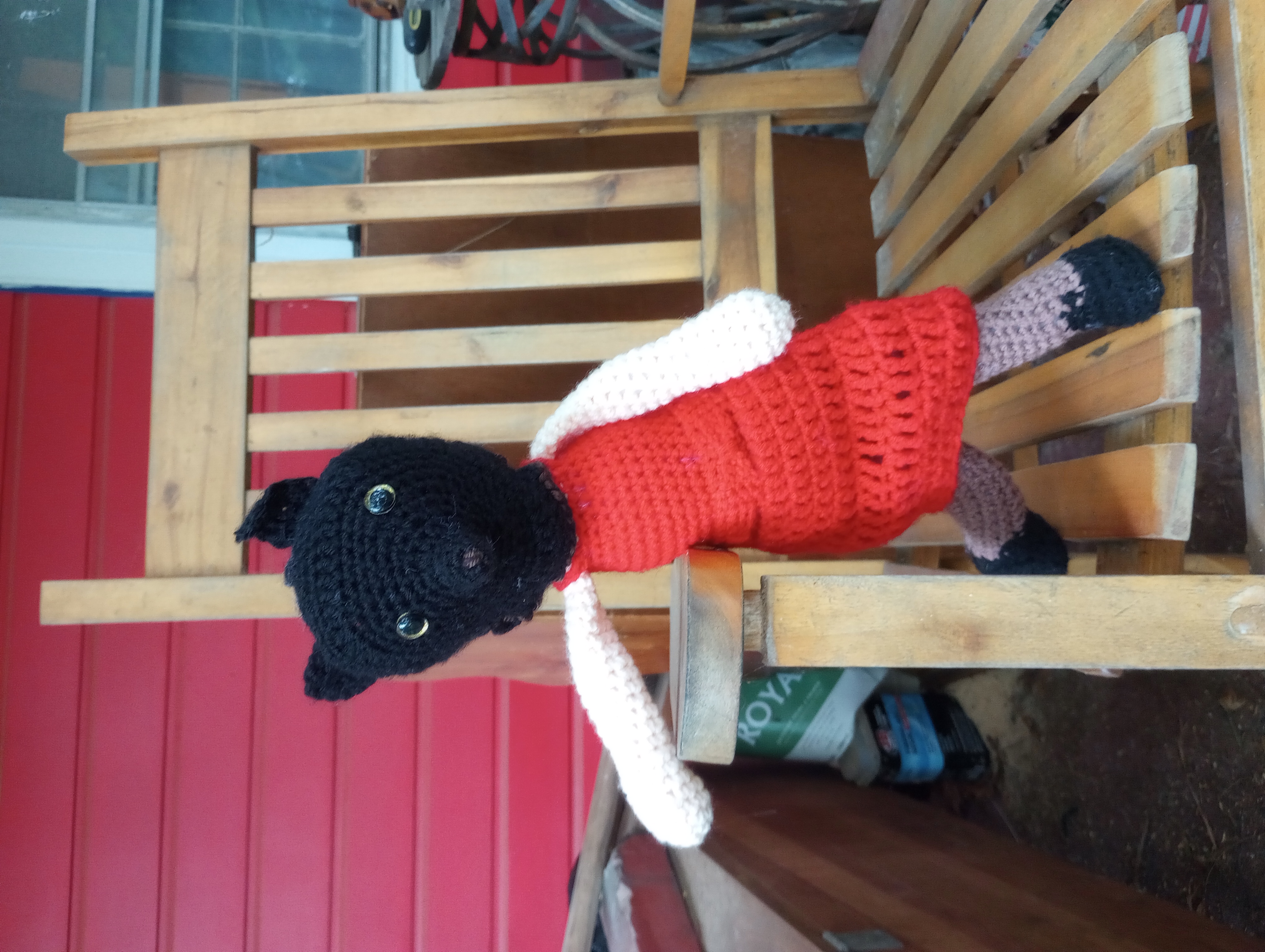 The same doll, but with her face and hair replaced with a black wolf's face with gold eyes, poised closer to the camera as if she is coming towards the viewer