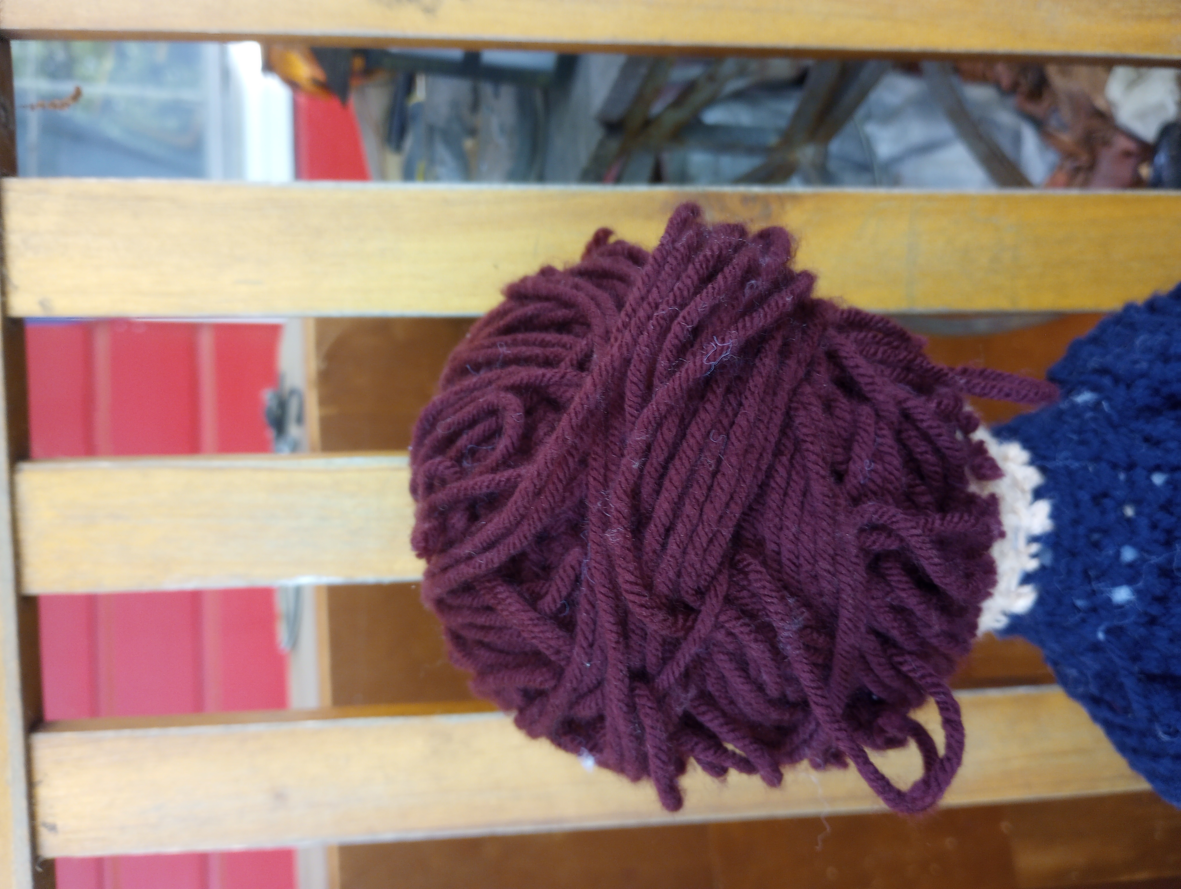 The back of Mina's head, showing the reddish-brown yarn has been woven across the back of the head into an updo