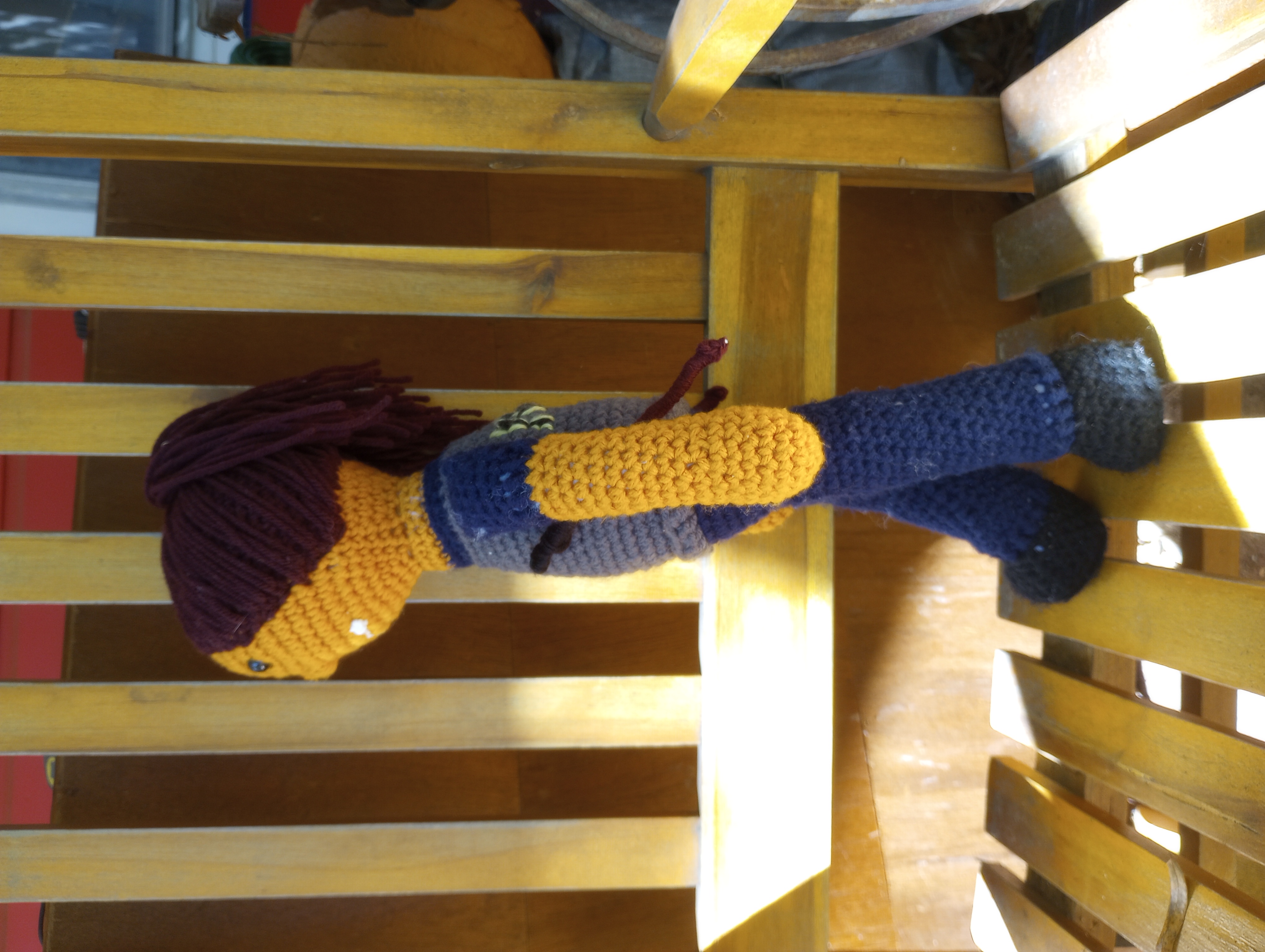 The same doll viewed from the side, showing the sticks to better effect as well as her ponytail